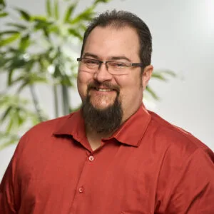 A headshot of Dan Bourrier smiling