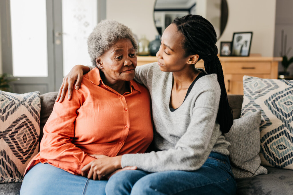 Young woman sitting on sofa with her mother