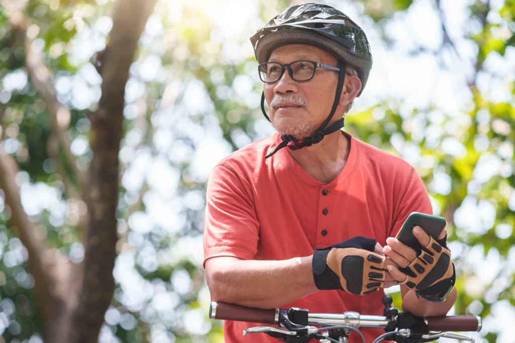 Older man sitting on bike wearing a helmet